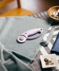 Top Tier Loop Handle Rotary Cutter For Heavy Duty Fabric And Vinyl Crafting Precision Ground Steel Blade on a sewing table with fabric.