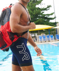 Man by pool with Big Mesh Mummy Backpack For Wet Swim Gear, Gym, And Beach Workout Essentials, 25.25 x 19 in, red mesh.