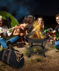 Extra Large Fire Pit BBQ Grill Bowl With Mesh Spark Screen Cover, Poker And Tote Bag in use at a bonfire setting with friends