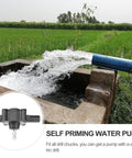 Water flowing from a self-priming electric drill pump into a stone tank in a green field. Ridiculously Compact Electric Drill Pump For Water Transfer Self Priming Liquid Mover With Power Tool Adapter No Fuss Setup Dang Sweet For Oil And Yard Jobs.