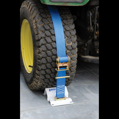 Heavy Duty E Track Wheel Chock Tie Down Kit with blue ratchet strap securing a tractor tire for safe ATV hauling.