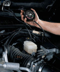Hand-held Hromee fuel pump and vacuum tester gauge in engine bay with hoses