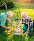 Two people using Padded Garden Kneeler And Seat Bench With Extra Thick Foam in a garden while picking apples from a basket.