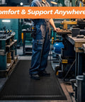 Person standing on Anti Fatigue Standing Mat For Industrial Kitchens And Workshops, 2 Ft By 5 Ft, 15/16 Inch Thick Ergonomic Memory Foam Cushioned Floor Mat With Diamond Plate Texture, Heavy Duty Back And Leg Pain Relief For Long Shifts in workshop setting
