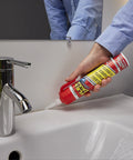 Flex Caulk 9 oz white hybrid polymer sealant being applied along bathroom sink edge (side view)