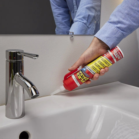 Flex Caulk 9 oz white hybrid polymer sealant being applied along bathroom sink edge (side view)