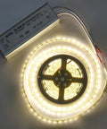 Go-To 300W LED Driver 24V DC Power Supply with 3-prong plug and waterproof enclosure next to coiled LED strip light