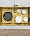 Rock Solid Gold 304 Stainless Steel Sink Grid Protector Covers 28 by 14 Inch Single Bowl with Rear Drain holding cookware in sink.