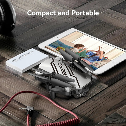 D20 Mini Drone For Kids with 1080P FPV Camera beside tablet and book, compact and portable, folded on wooden surface, Silver version
