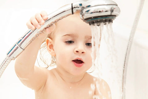 Child holding a showerhead, enjoying water flow, highlighting the ease of use of the Score Instant Hot Water With This Beast-Mode 26.9 KW Electric Tankless Water Heater Engineered For Full Whole-House Flow With Zero Fuss Super Easy Install For Any Gig 3Phase 240V Power Gets You Streaming Hot Water Fast Reliable Goods For Home Or Business.