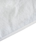 Close-up of ironing board cover with thick three-layer padding, 100% cotton, showing texture and elasticized skirt edge.