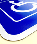 Heavy Duty Aluminum Handicap Parking Sign Ada Compliant Reflective Metal Plaque featuring rounded edges and bright blue background.