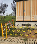 Tough As Nails Traffic Barricade Heavy Duty Industrial Crowd Control Barrier For Construction Zones And Large Gatherings Uv Resistant FRP Expandable Safety Fence Red White in expanded position beside building.