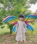Child wearing Fairy Wing Balloon Costume Set for Halloween Party and Cosplay with rainbow foil angel butterfly wings outdoors