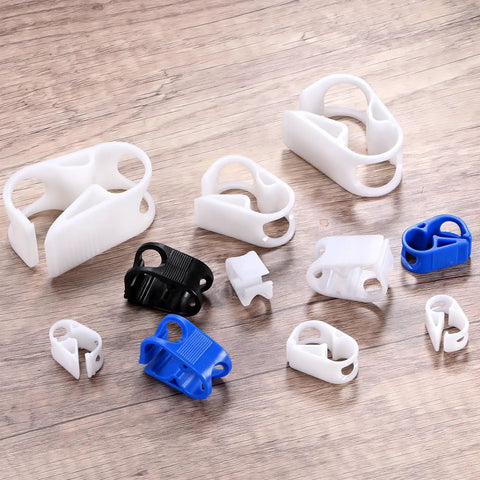 White plastic tubing clamps of various sizes for Five Pack Adjustable Plastic Tubing Clamps For Beer Bottles Plumbing Aquarium And Irrigation Setups Water Flow Control Tube Clips Heavy Duty Hose Clips For Instruments And Equipment displayed on wood surface.