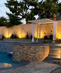 Elegant back patio with Out Of The Box Low Voltage Outdoor Uplights And Spotlight Kit highlighting wall and plants at night