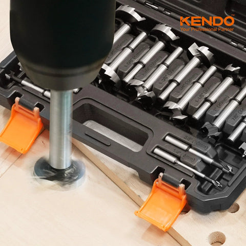 Front view of KENDO 16-piece alloy steel Forstner bit set in storage case with drill and wood workpiece