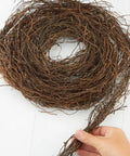 Hand holding curled Dried Natural Grapevine Twig Garland 15 Ft Cozy Rustic Angel Vine Decor For Year Round Farmhouse Vibe