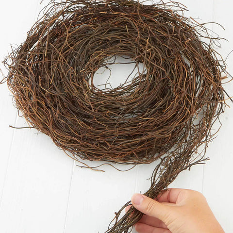 Hand holding curled Dried Natural Grapevine Twig Garland 15 Ft Cozy Rustic Angel Vine Decor For Year Round Farmhouse Vibe