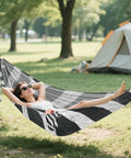 Person lounging in a Zebra Inspired Camping Hammock With Tree Straps And Travel Bag Easy Setup No Knot Straps Ultra Thickened Durable hammock in a forest
