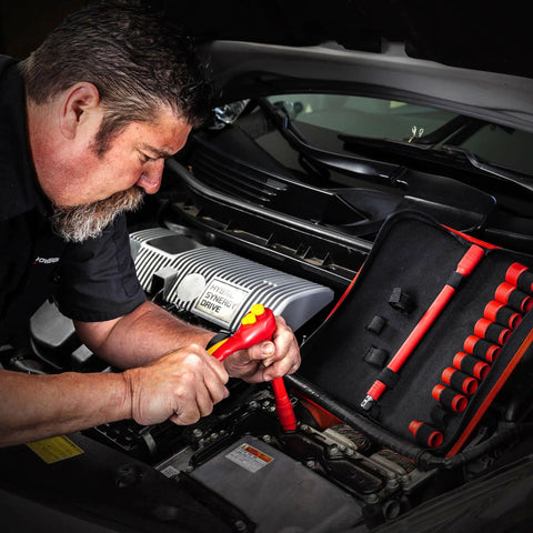 Man using Straight Up Tough 13 Piece VDE Insulated Tool Set with ergonomic ratchet socket on hybrid vehicle engine.
