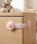 8 Pack Baby Proof Cabinet Locks No Drill Adhesive Mount Safety Locks on a wooden cabinet with pink smiley design
