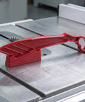 Rock Solid Table Saw Push Stick With Riving Knife Splitter 16.5 Inches Long on table saw, sturdy red plastic construction.