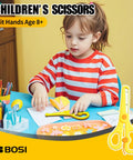 Child using BOSI children's scissors on craft project at desk with paper and pencils, suitable for ages 8 and up.