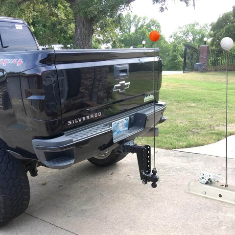 Two Pack Tall Adjustable Magnetic Trailer Alignment Kit With Extendable Poles For Boat Trailers, RVs, Campers, Horse Trailers And Cargo, Magnetic Hitch Line Up With Visible Red And White Balls, No Fuss Easy Height Adjustment installed with truck and trailer in driveway.