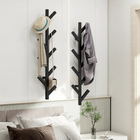 Wall Mounted Metal Coat Rack With Nine Hooks in black with coats and hats, mounted on a wall in a modern bedroom.