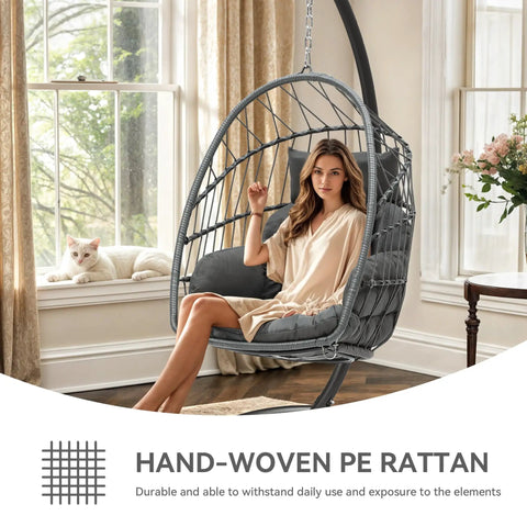 Woman sitting in Chill Outdoor Hanging Egg Chair With Stand For Patio And Garden, Cushioned Wicker Rattan Swing Chair Up To 300 Lbs, Perfect For Balcony Or Bedroom, Gray, in a sunlit room.