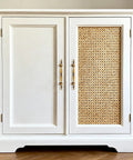 White cabinet with woven rattan door and antique brass cabinet pulls, highlighting the 10 pack of classic vintage style hardware.