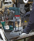 Heavy Duty One Half Inch High Torque Drill With Solid Six Point Seven Amp Motor And Wide Speed Range From Zero To Six Hundred Fifty Rpm in use on workshop table.