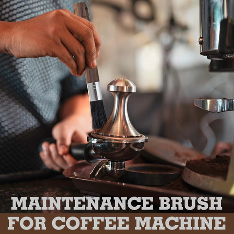 Barista cleaning brush with wooden handle and black boar bristles being used on a shiny espresso machine component