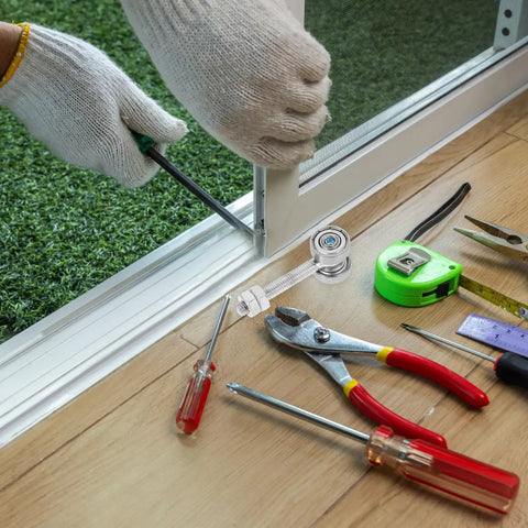 Tough As Nails Dual Wheel Sliding Door Roller Pulley installation process with tools and gloves on wooden floor.