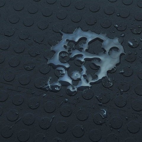 Close-up of water-resistant surface on interlocking 18 by 18 inch raised coin floor tile for home gym garage basement.