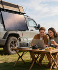 Road Ready Portable Solar Generator With 1056 Wh LiFePO4 Battery And 1600 W Ac Output Packs Serious Juice Via Foldable 100 Watt Panel used by campers at a table.