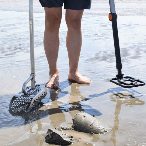 Person using Stainless Steel Sand Scoop For Metal Detecting Adjustable Handheld Treasure Hunter Shovel on wet beach sand