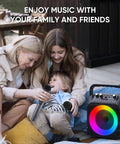 Family using Totally Party-Ready Portable Bluetooth Karaoke System With Two Wireless Mics, LED Lights; joyful outdoor moment