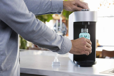 Person using Aquamega 100 Countertop Water Purifier With Three Stage Filtration and Direct Flow Technology No Power Needed Easy Install Tankless.