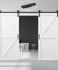 Rock Solid 72X84 K Shape Barn Door Crafted From Premium Kiln Dried MDF With Full Hardware Kit showing two white sliding doors on a gray wall.