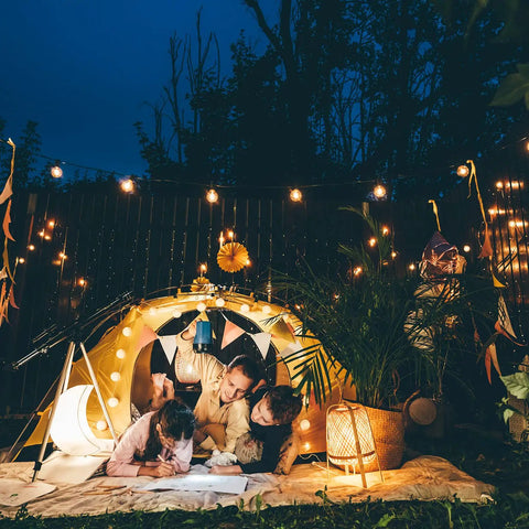 Family enjoying evening under Lit 50 Foot Outdoor LED String Lights With 27 Plastic G40 Bulbs And 2 Spare, IP65 Edison Globe