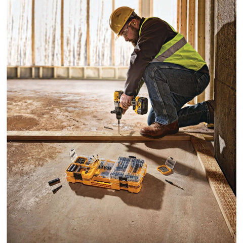 DEWALT 40-piece steel screwdriver bit set in yellow case; construction worker uses cordless drill.