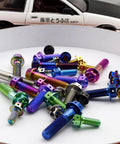 Assorted burnt-blue titanium bolts with flange and hex heads, M6x12mm, colorful finishes scattered on white surface.