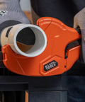 Ratcheting PVC Pipe Cutter For 2 Inch ID Pipes And 2 3 Eighths Inch OD, One Handed Operation, Lightweight Soft Grip Handles, Replaceable Blades, Cuts Schedule 40 And 80 PVC CPVC And PEX. Orange ratcheting PVC pipe cutter gripping 2-inch plastic pipe