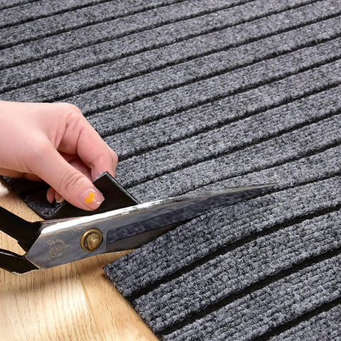 Cutting a gray textured mat with scissors on a wooden surface for the Solid Coffee Tamping Station With A Slick Integrated Espresso Knock Box And Grippy Portafilter Holder Tailored For 58Mm Barista Mats To Keep Counters Clutter Free And Grounds Zero Hassle To Clean.
