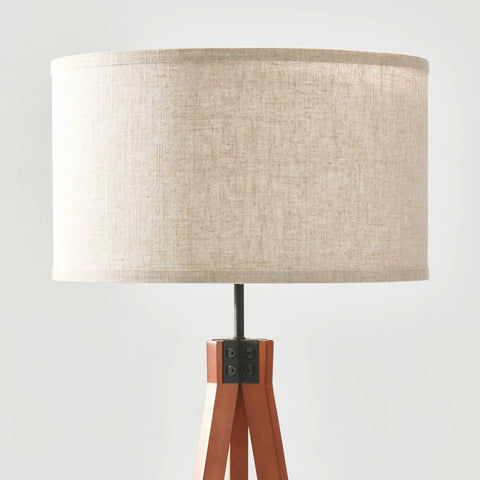 Close-up of Eden Tripod Floor Lamp Dimmable LED With Solid Wood Legs, showing beige drum shade and wooden base details.
