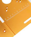 Orange aluminum router table insert plate, close-up view with ruler scale and mounting holes.