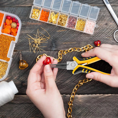 Person using pliers from 8-Piece Jewelry Pliers Kit With Storage Bag For Beading And DIY Jewelry Repair on a heart pendant