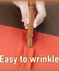 Go-To Stiletto and Pressing Tool for Quilting and Sewing used on brown fabric, close up of hand holding the wooden handle